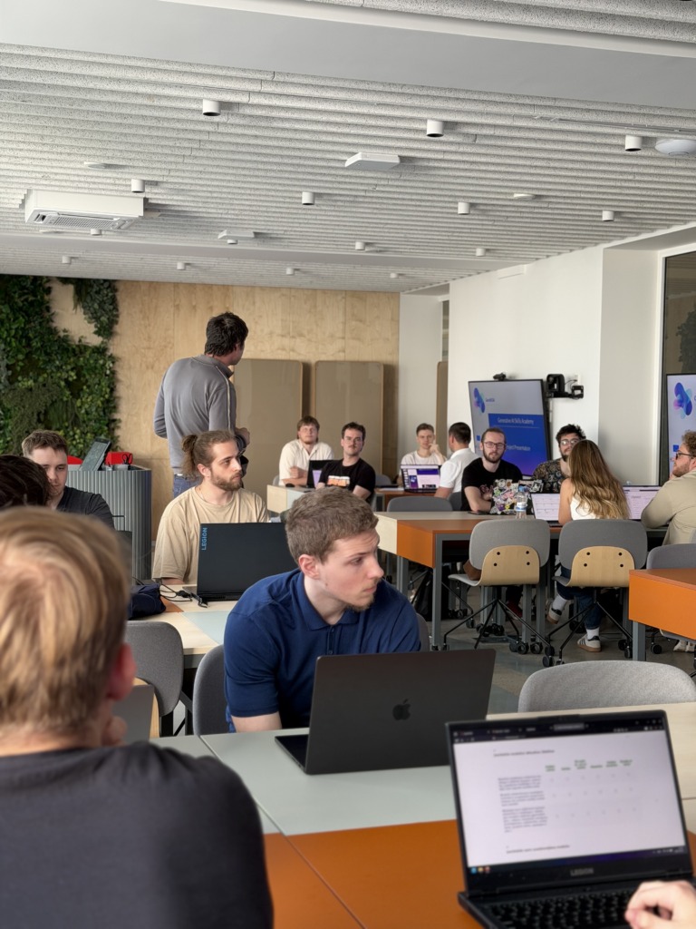 Students sit around a laptop during a GenAISA workshop on generative AI skills in education.